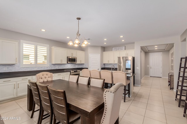 tiled dining space featuring an inviting chandelier