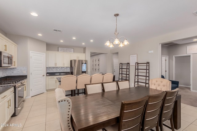 dining area with a chandelier and light tile patterned flooring