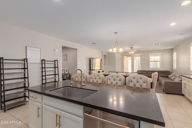 kitchen featuring stainless steel dishwasher, sink, an island with sink, white cabinetry, and light tile patterned flooring