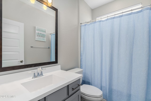 bathroom with walk in shower, vanity, and toilet