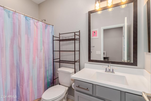 bathroom featuring vanity, curtained shower, and toilet