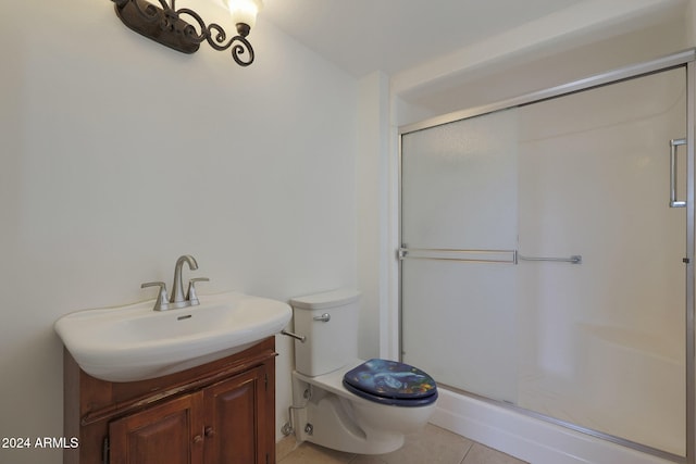 bathroom featuring tile patterned flooring, an enclosed shower, vanity, and toilet