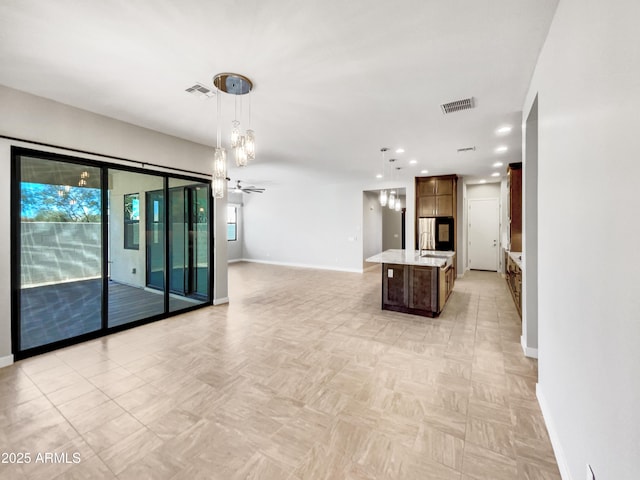 kitchen with sink, ceiling fan, pendant lighting, and a center island