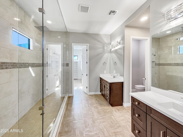 bathroom with toilet, tiled shower, parquet floors, and vanity