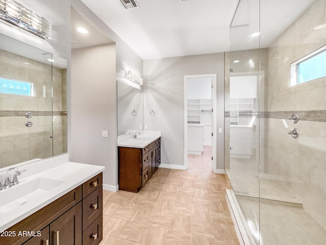 bathroom with tiled shower and vanity