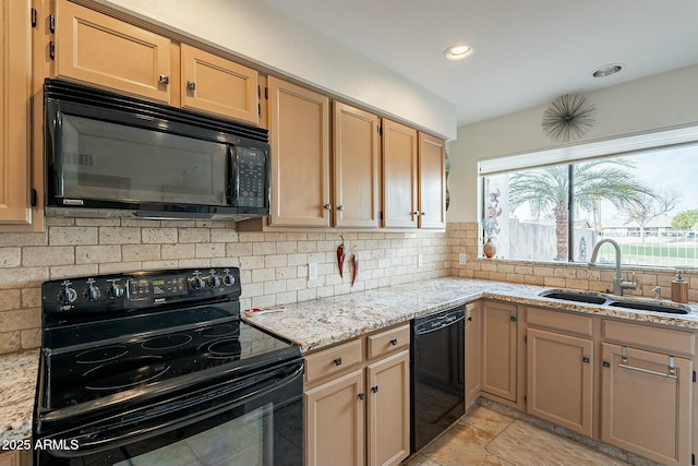 kitchen featuring tasteful backsplash, light stone counters, sink, and black appliances