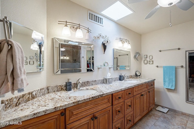 bathroom featuring vanity, ceiling fan, and a skylight