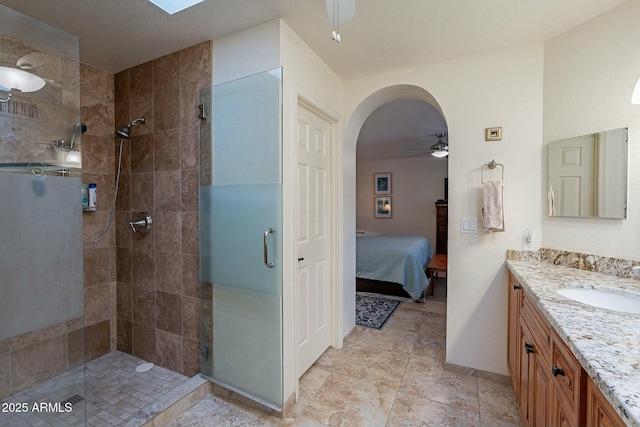 bathroom with ceiling fan, a shower with door, and vanity