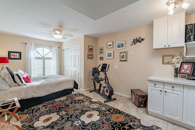 bedroom featuring light tile patterned floors, a closet, and ceiling fan