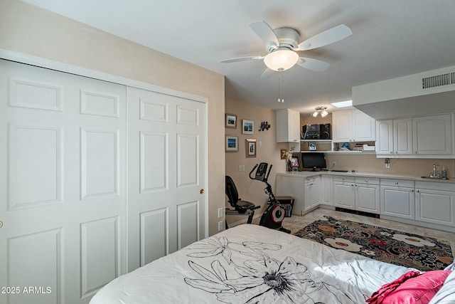 bedroom featuring ceiling fan, light tile patterned flooring, sink, and a closet