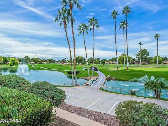 view of property's community with a yard and a water view