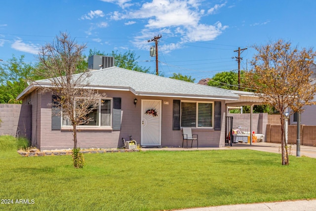 single story home featuring brick siding, central air condition unit, a shingled roof, a front yard, and fence