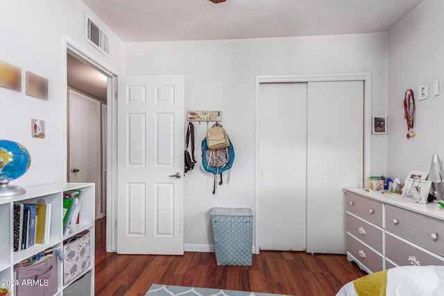 bedroom featuring a closet, visible vents, and wood finished floors