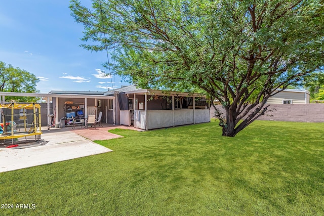 view of yard with a patio area, a trampoline, and fence