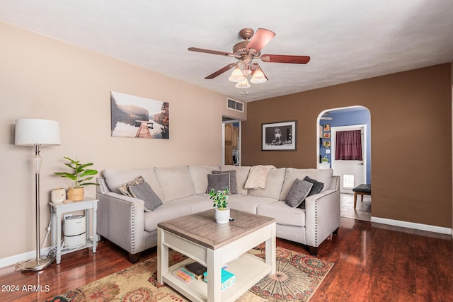 living area featuring arched walkways, visible vents, ceiling fan, and wood finished floors