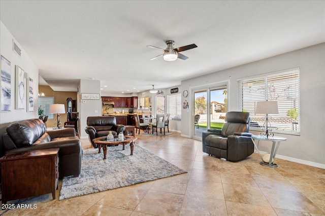 living area featuring visible vents, baseboards, a ceiling fan, and light tile patterned flooring