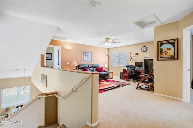 carpeted living area with a wealth of natural light, visible vents, and baseboards