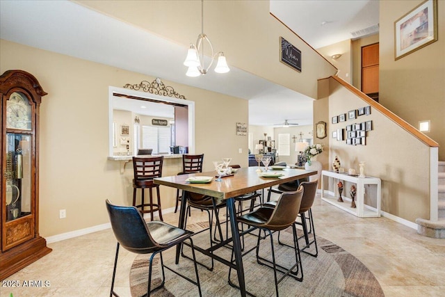 dining area with light tile patterned floors, visible vents, baseboards, stairs, and ceiling fan with notable chandelier