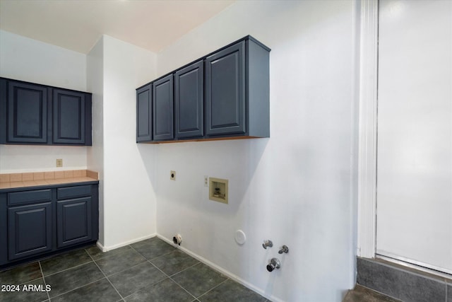 laundry room featuring cabinets, hookup for an electric dryer, gas dryer hookup, hookup for a washing machine, and dark tile patterned flooring