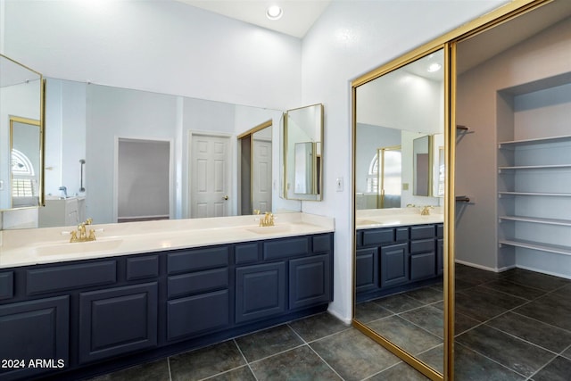 bathroom featuring tile patterned flooring, vanity, and lofted ceiling