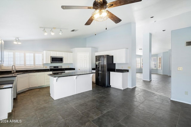 kitchen featuring white cabinetry, ceiling fan, stainless steel appliances, a kitchen breakfast bar, and a kitchen island