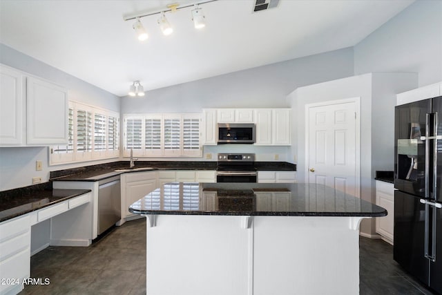 kitchen featuring a center island, sink, stainless steel appliances, vaulted ceiling, and white cabinets