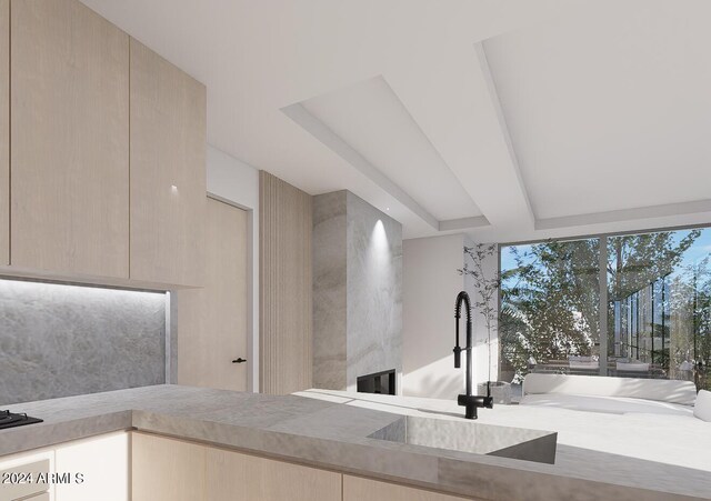 kitchen featuring light hardwood / wood-style flooring, oven, light brown cabinets, and black cooktop