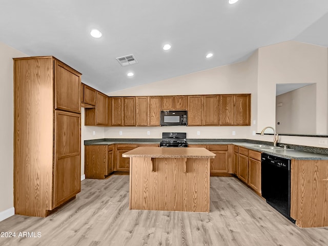 kitchen featuring black appliances, light hardwood / wood-style floors, lofted ceiling, and sink