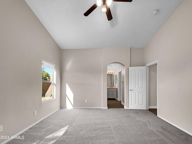 carpeted spare room with high vaulted ceiling and ceiling fan