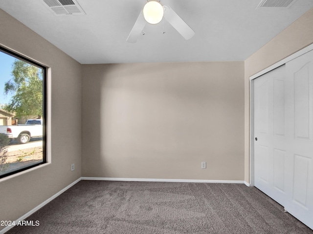 carpeted spare room with ceiling fan