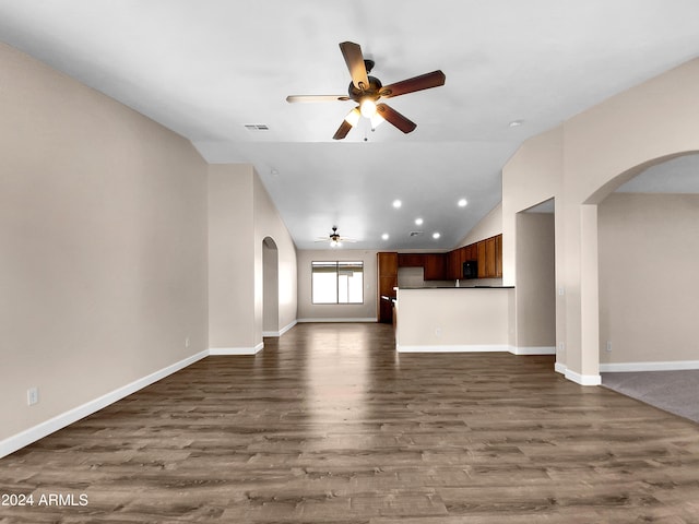 unfurnished living room featuring ceiling fan, dark wood-type flooring, and vaulted ceiling