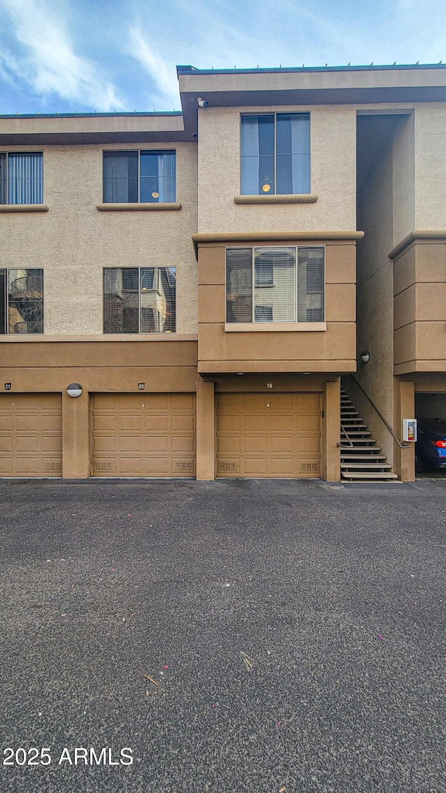 view of property with a garage and stucco siding