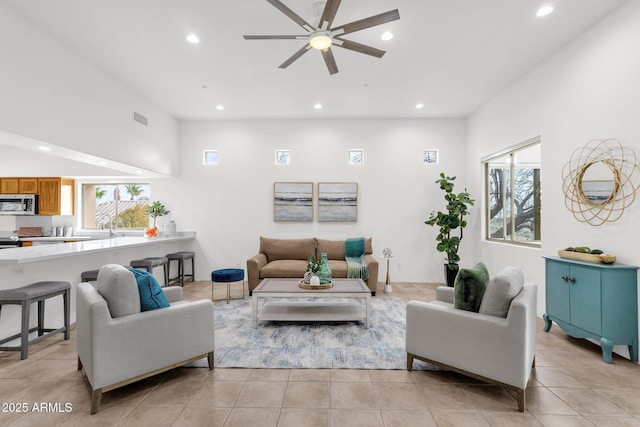 living area with light tile patterned floors, a ceiling fan, visible vents, and recessed lighting