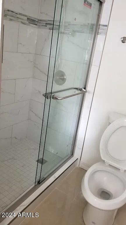 bathroom featuring walk in shower and toilet