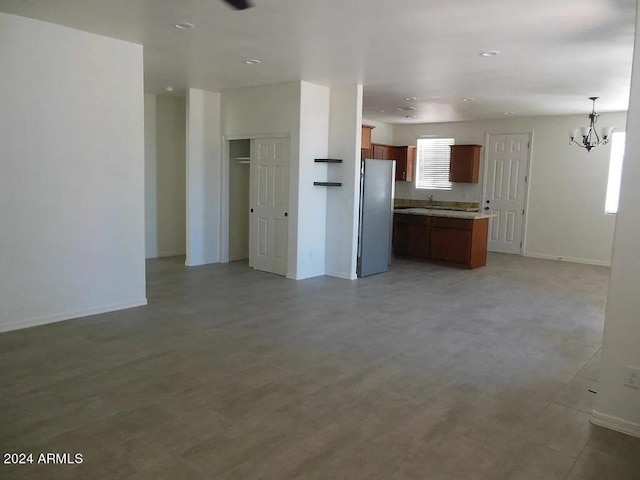 kitchen with stainless steel fridge, a notable chandelier, and hanging light fixtures