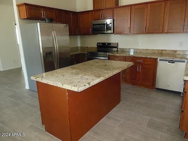 kitchen featuring a center island, light stone counters, and appliances with stainless steel finishes