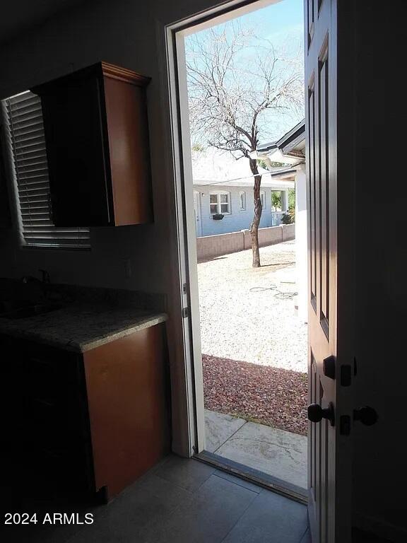 doorway with sink and light tile patterned flooring