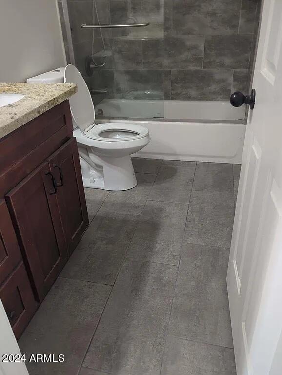 full bathroom featuring tile patterned floors, toilet, tiled shower / bath combo, and vanity