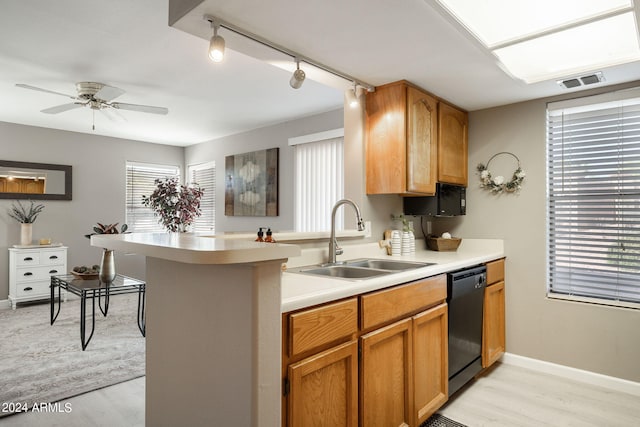 kitchen featuring rail lighting, sink, light hardwood / wood-style flooring, black dishwasher, and kitchen peninsula