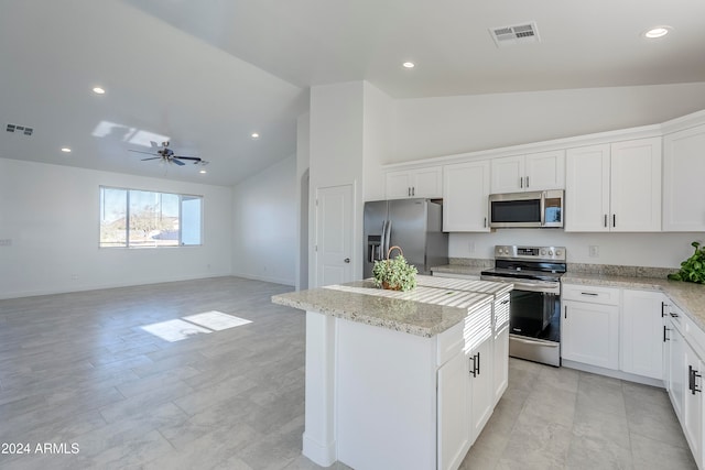 kitchen featuring white cabinetry, ceiling fan, stainless steel appliances, light stone counters, and an island with sink