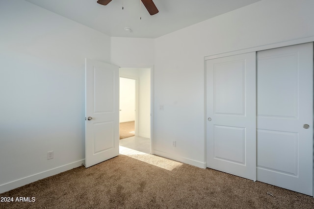 unfurnished bedroom featuring ceiling fan, a closet, and carpet