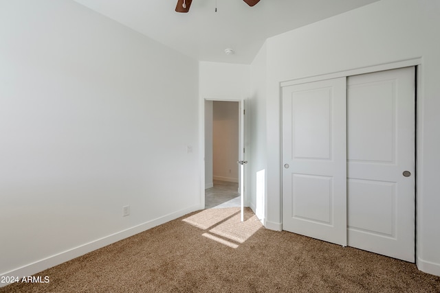 unfurnished bedroom featuring carpet flooring, ceiling fan, and a closet