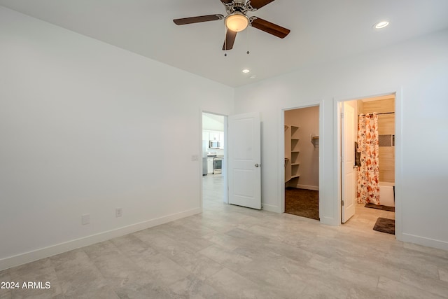 unfurnished bedroom with connected bathroom, a closet, a spacious closet, and ceiling fan