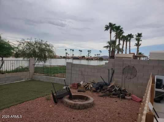 view of yard featuring a water view and a fenced backyard