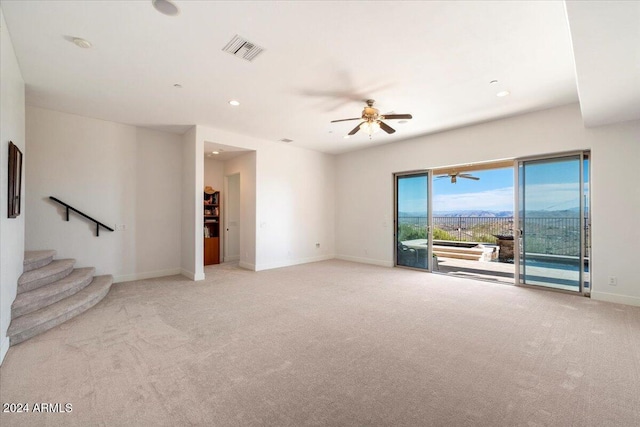 unfurnished living room featuring light carpet and ceiling fan