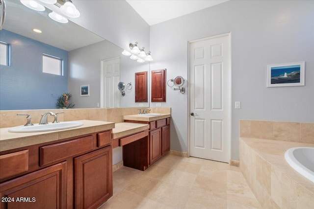 bathroom with tile patterned flooring, vanity, and a relaxing tiled tub