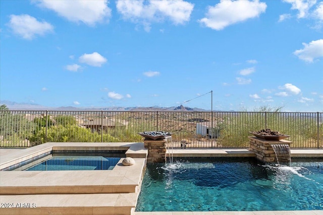 view of pool featuring pool water feature and an in ground hot tub