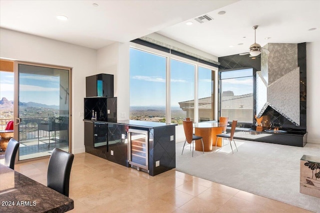 kitchen featuring wine cooler, ceiling fan, a mountain view, and light colored carpet