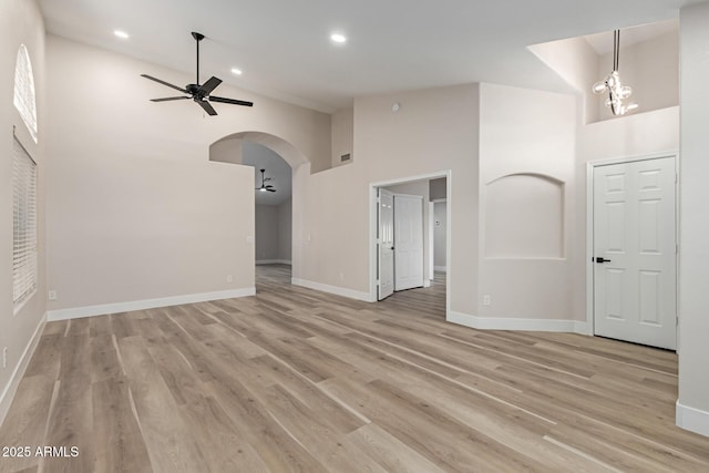 2189 E Ranch Ct, Gilbert, AZ 85296 - unfurnished living room featuring high vaulted ceiling, a ceiling fan, light wood-type flooring, baseboards, and arched walkways
