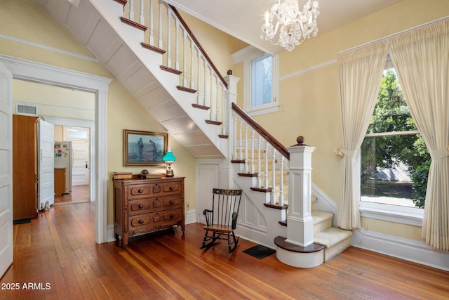 7252 N Central Ave, Phoenix, AZ 85020 - stairs featuring wood-type flooring, plenty of natural light, a chandelier, and baseboards